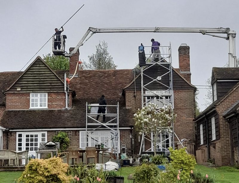 The Moss Cleaners using cherry picker and scaffolding to clean roof safely and professionally in Farnham, Surrey